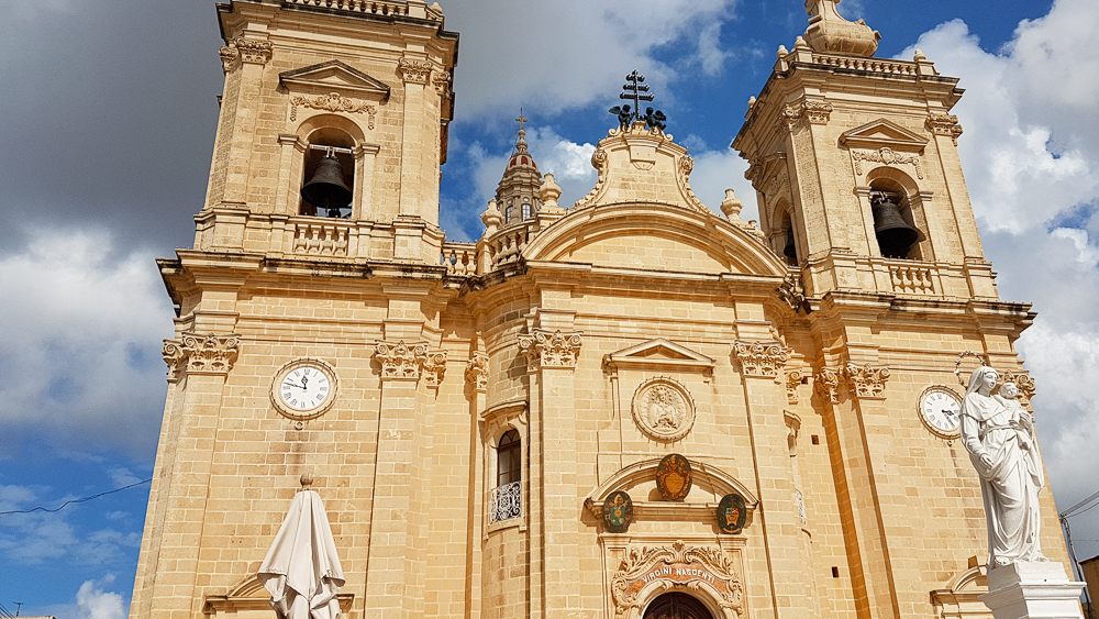 tipica chiesa maltese con doppio campanile e orologi che non segnano mai lo stesso orario